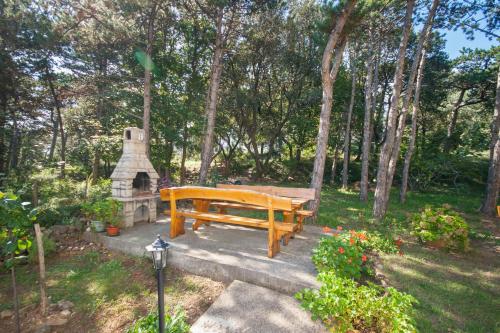 a wooden bench in a garden with a stone oven at Apartments Gracia in Baška