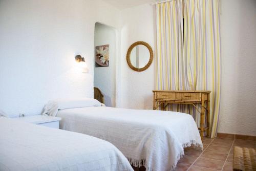 マルベーリャにあるCasa Sasのベッド2台と鏡が備わるホテルルームです。