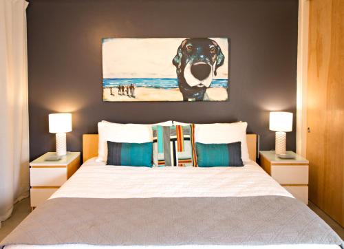 a bedroom with a bed with a painting of a dog at Modern Casita in Historic Downtown Albuquerque in Albuquerque