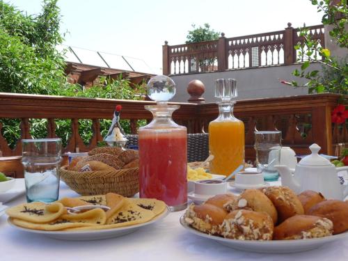 a table with plates of food and two bottles of juice at Riad Flam & Spa in Marrakech