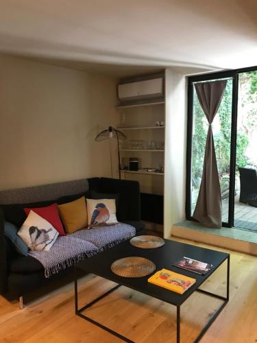 a living room with a couch and a table at T2 centre ville avec extérieur in Avignon