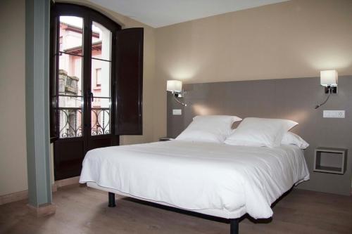 a large white bed in a room with a window at Hotel Areces in Grado