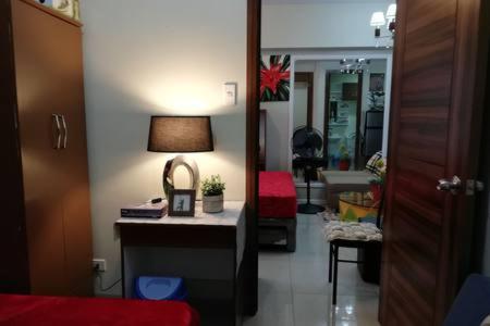 a room with a desk with a lamp on a table at Nica's Place Property Management Services at Horizons 101 Condominium in Cebu City