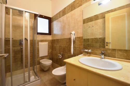 a bathroom with a sink and a toilet and a shower at Hotel Ristorante Il Vascello in Costa Rei