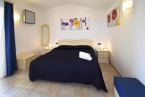 a bedroom with a black bed with two night stands at Hotel Ristorante Il Vascello in Costa Rei
