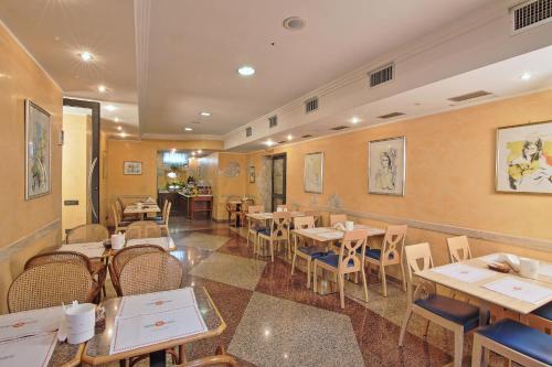 a restaurant with tables and chairs in a room at Hotel Aurora in Tivoli Terme
