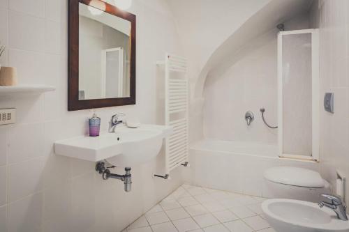 bagno bianco con lavandino e specchio di Il Gattopardo B&B a Firenze