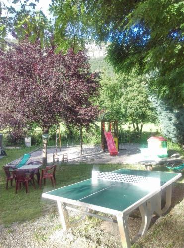 a ping pong table in a park with a playground at Camping du lac in Saint-Julien-du-Verdon