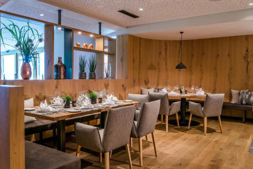 a restaurant with wooden walls and tables and chairs at Hotel Der Bär in Ellmau