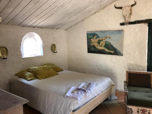 CoursegoulesにあるMaison Martheのベッドルーム1室(ベッド1台付)が備わります。壁には絵画が飾られています。