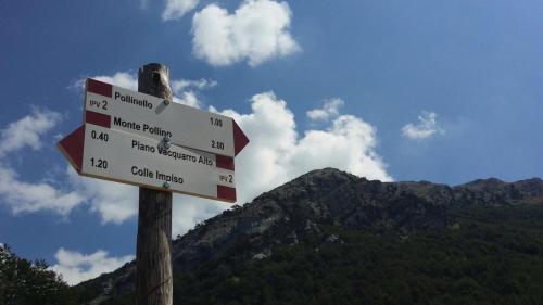a sign on a wooden pole with mountains in the background at Maria Guesthouse in Morano Calabro