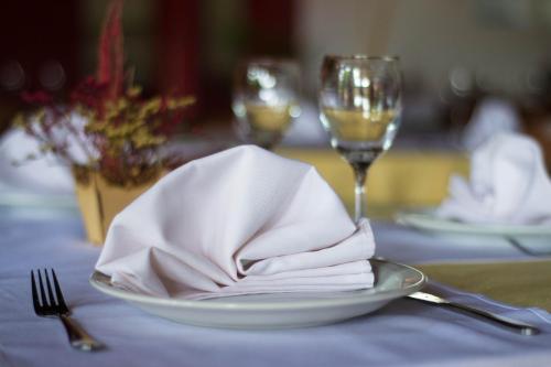 a plate with a napkin on a table with wine glasses at Marcopolo Suites Iguazu in Puerto Iguazú