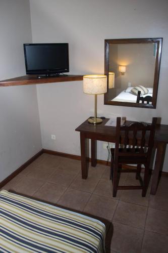 a bedroom with a desk and a mirror and a bed at Marcopolo Suites Iguazu in Puerto Iguazú