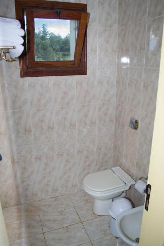a bathroom with a toilet and a window at Marcopolo Suites Iguazu in Puerto Iguazú