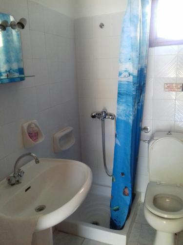 a bathroom with a sink and a toilet and a shower at Fountas Apartment in Parga