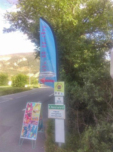 a sign on the side of a road with a banner at Camping du lac in Saint-Julien-du-Verdon