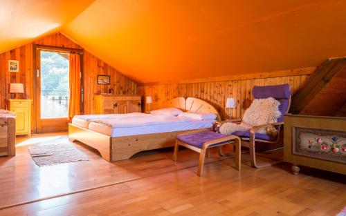 a bedroom with a bed and a chair and a fireplace at Kitzecker-Weingartenhaus in Kitzeck im Sausal