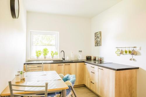 a kitchen with wooden cabinets and a table and a window at Bielski Zakątek bezobsługowy in Bielsko-Biała