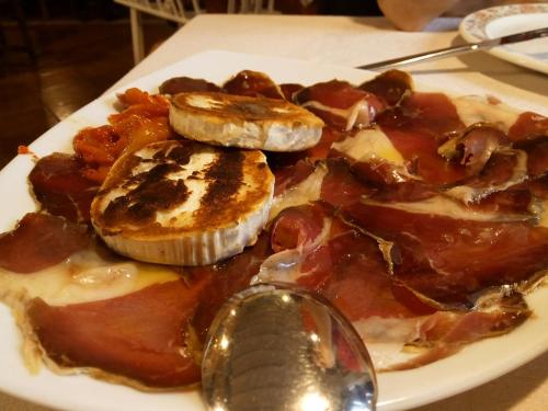 a plate of food with bacon and meat and a spoon at Hostal casa lucas in Los Tojos