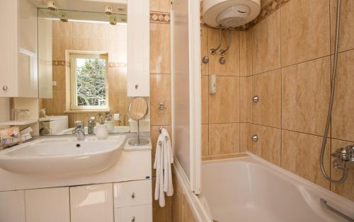 a bathroom with a sink and a bath tub at Penthouse Fantasia in Dubrovnik