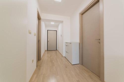 an empty hallway with white walls and wooden floors at Apartments Krug in Budva
