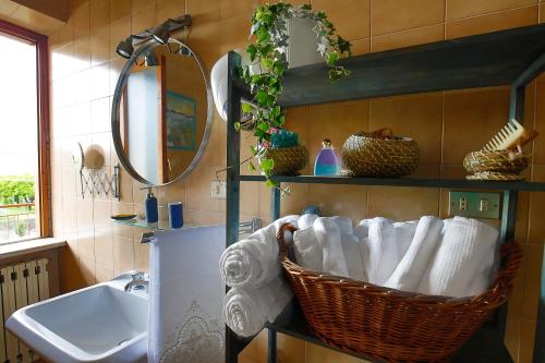 - Baño con lavabo y cesta de toallas en Casa in villa nel Parco del Vesuvio, en Pollena Trocchia