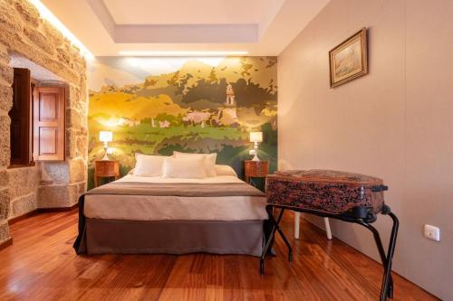 a bedroom with a bed and a painting on the wall at Pazo de Esposende in Esposende