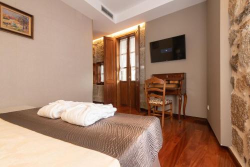 a bedroom with a bed and a table and a desk at Pazo de Esposende in Esposende