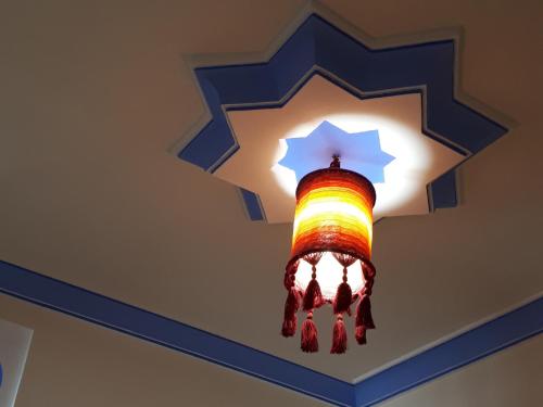 un lampadario colorato appeso a un soffitto di Dar Al Machichi a Chefchaouen