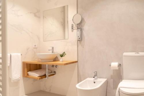 a white bathroom with a sink and a toilet at Pazo de Esposende in Esposende