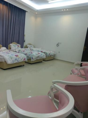 a room with three beds in a room at Alarbee Aljeded in Salalah