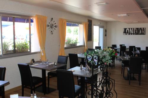 a dining room with tables and chairs and windows at HOTEL Chateau-Thierry Centre in Château-Thierry