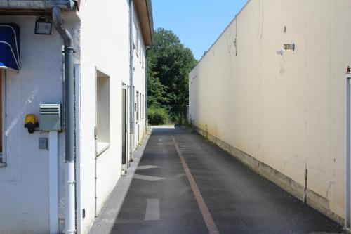an empty alley between two white buildings at HOTEL Chateau-Thierry Centre in Château-Thierry