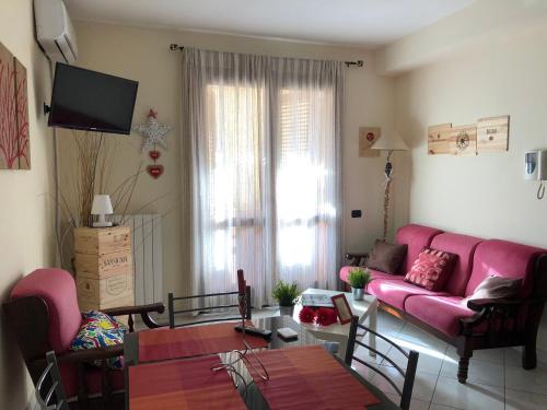 un soggiorno con divano rosa e tavolo di Gaia House a Oristano