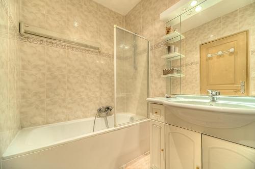 une salle de bain avec un lavabo et une baignoire et un lavabo dans l'établissement Residence Chryseis, à Cannes