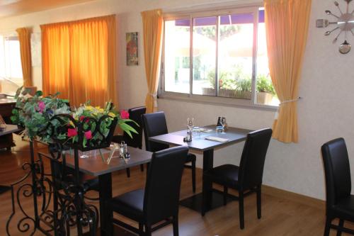 a dining room with two tables and chairs and a window at HOTEL Chateau-Thierry Centre in Château-Thierry