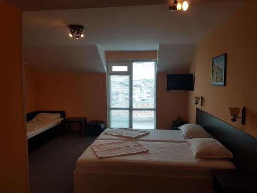 a hotel room with two beds and a window at Boruna Guest House in Sozopol