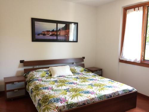 1 dormitorio con 1 cama y una foto en la pared en Casa Lorenzo, en Bellagio