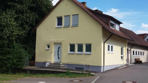 una casa amarilla con techo marrón en Ferienwohnung Biermann, en Aspach