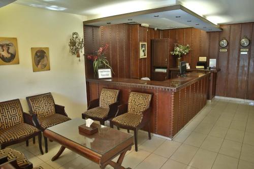 a waiting room with a reception desk and chairs at Hisham Hotel in Amman