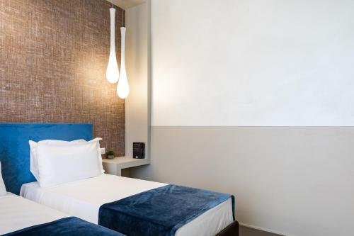 a room with two beds and a brick wall at A World Aparts - Barberini Boutique Hotel in Rome