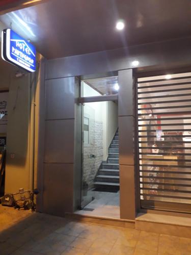 an entrance to a building with a door and stairs at Parthenon Hotel in Souda