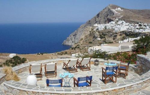 a group of chairs and tables and the ocean at Belvedere Apartments in Chora Folegandros