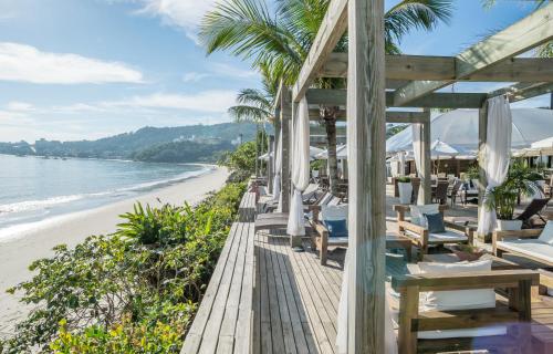 a restaurant on the beach with chairs and umbrellas at Pousada dos Sonhos in Florianópolis