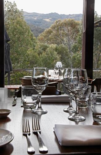a table with wine glasses on a table with a view at The Denman Hotel in Thredbo in Thredbo