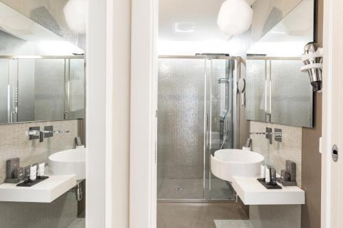 a bathroom with two sinks and a shower at A World Aparts - Barberini Boutique Hotel in Rome