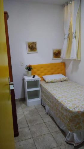 a small bedroom with a bed and a night stand at Pousada Brenda in Fortaleza