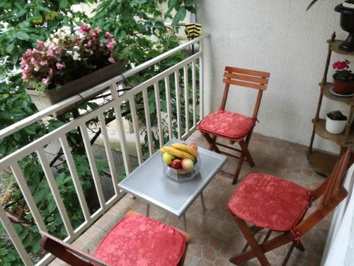 a table and two chairs and a bowl of fruit on a balcony at Cherry flower ( Trešnjin Cvet ) apartment in Višegrad