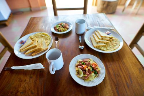 a wooden table with plates of food on it at Wli Water Heights Hotel in Wli Afegame