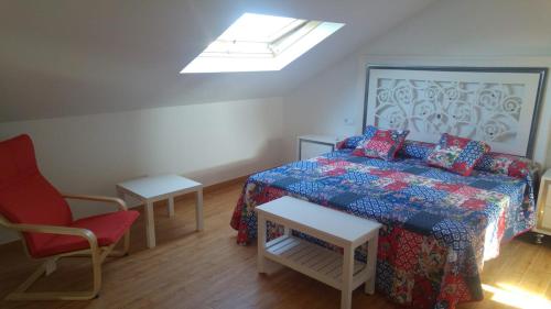 a bedroom with a bed and a chair and a skylight at Casa A Veiga in O Grove